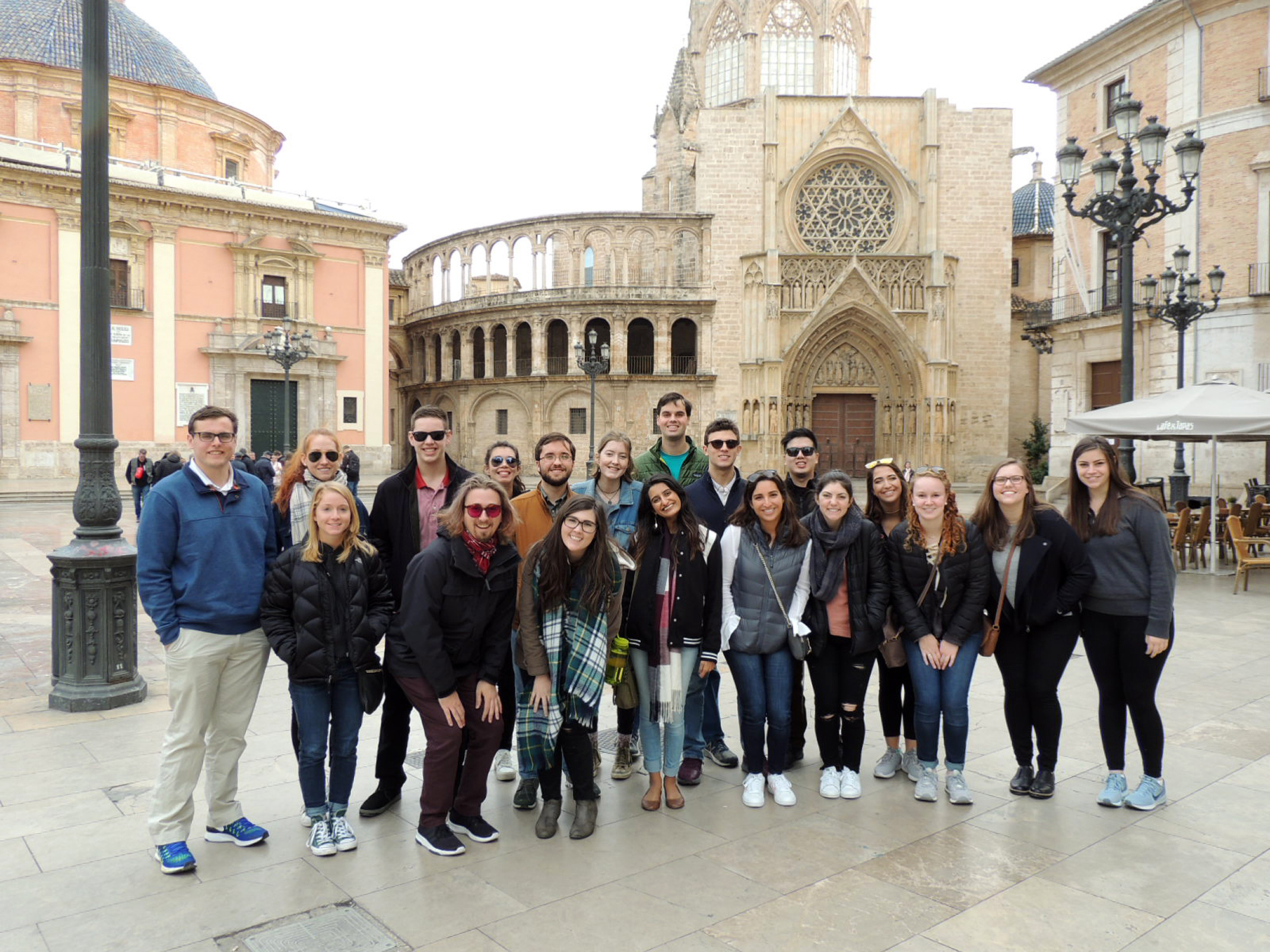 A large group of students stand at the Plaza Virgen in Valencia during the Spring 2018 study abroad trip