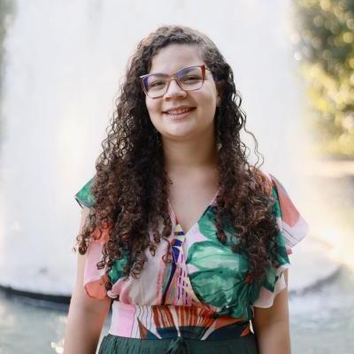 Gabriela poses for the picture. She is in front of a fountain.